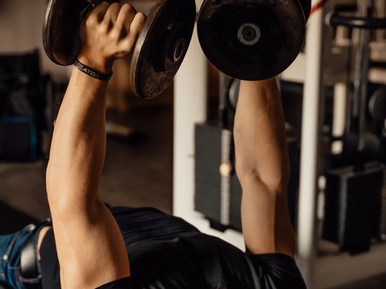 Lifter pressing dumbbells on a bench